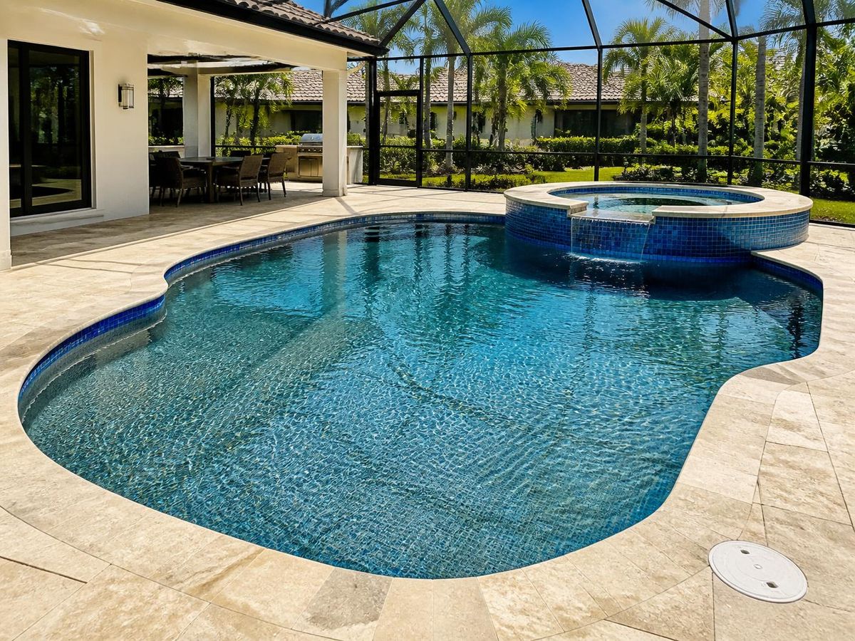 Renovated Naples Florida pool with new glass tile and travertine deck